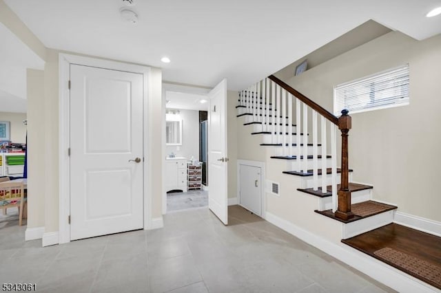 staircase with tile patterned flooring, visible vents, recessed lighting, and baseboards