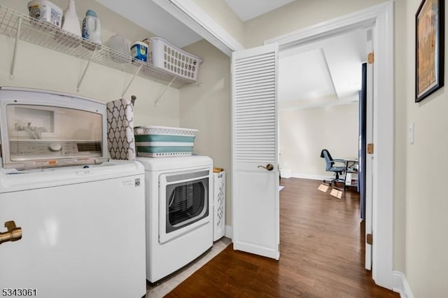 laundry room featuring laundry area, separate washer and dryer, dark wood-type flooring, and baseboards