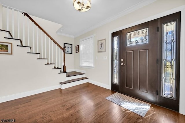 entrance foyer with stairway, baseboards, wood finished floors, and ornamental molding