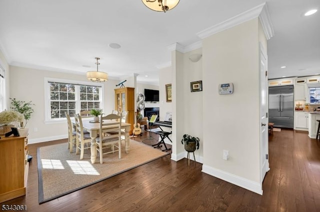 dining room with baseboards, dark wood finished floors, recessed lighting, a fireplace, and crown molding