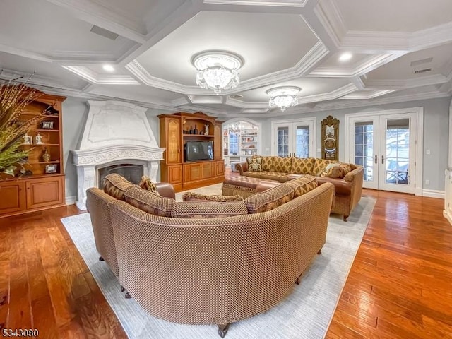 living room featuring a chandelier, french doors, a fireplace, and coffered ceiling