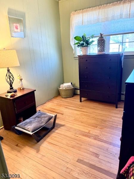 interior space featuring baseboard heating and wood finished floors