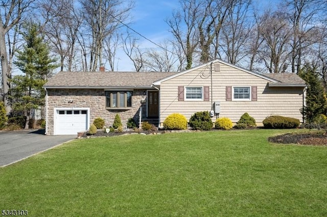 ranch-style house featuring a garage, a front lawn, a chimney, and aphalt driveway