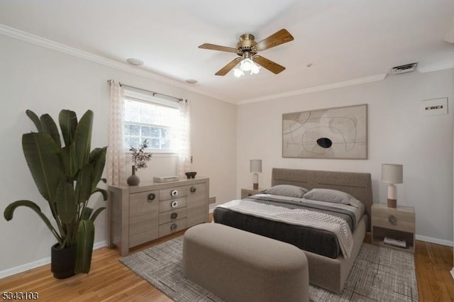 bedroom featuring light wood-style flooring, baseboards, visible vents, and ornamental molding