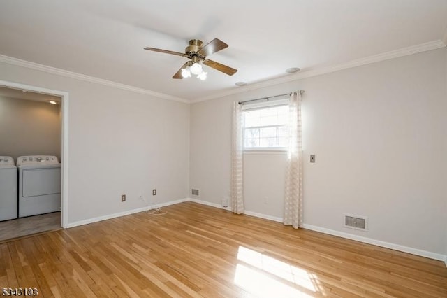 unfurnished room with visible vents, light wood finished floors, ornamental molding, ceiling fan, and washer and dryer