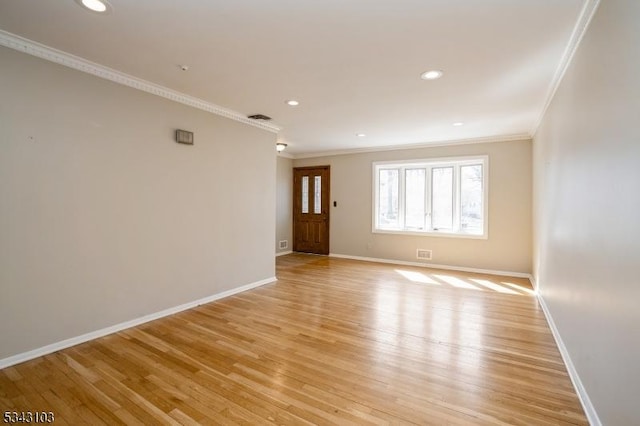 unfurnished room featuring visible vents, light wood-style flooring, baseboards, and ornamental molding