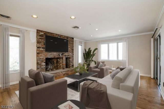 living room with light wood-style floors, visible vents, and ornamental molding