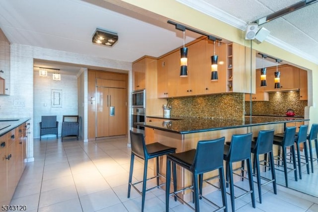 kitchen with paneled built in fridge, decorative backsplash, and crown molding