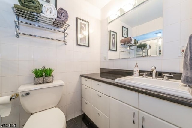 bathroom with vanity, tile walls, toilet, and tile patterned flooring