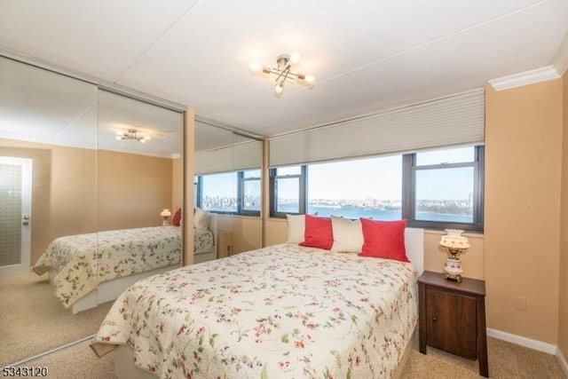 bedroom with carpet flooring, multiple windows, crown molding, and baseboards