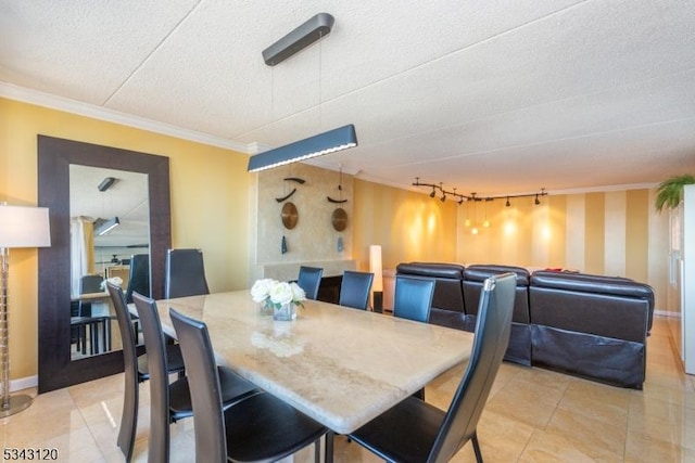 dining space with light tile patterned floors, baseboards, a textured ceiling, and crown molding