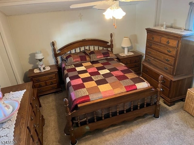 bedroom with a decorative wall, a ceiling fan, and carpet floors