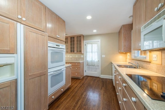 kitchen with dark wood finished floors, light countertops, recessed lighting, white appliances, and a sink