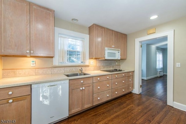 kitchen featuring white appliances, a sink, decorative backsplash, light countertops, and dark wood-type flooring