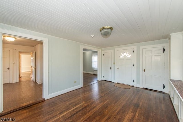 foyer featuring baseboards and dark wood-style flooring