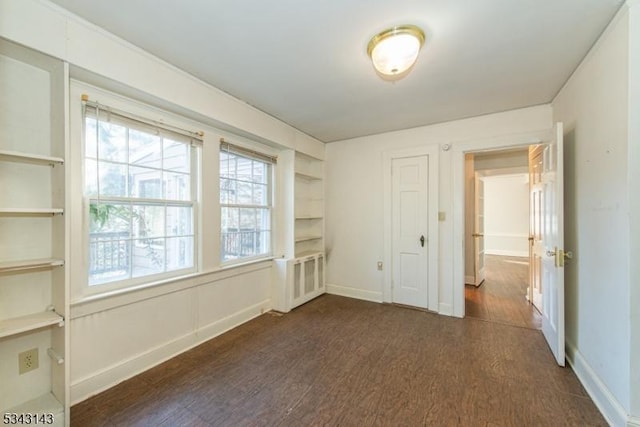 unfurnished bedroom with dark wood-style floors and baseboards