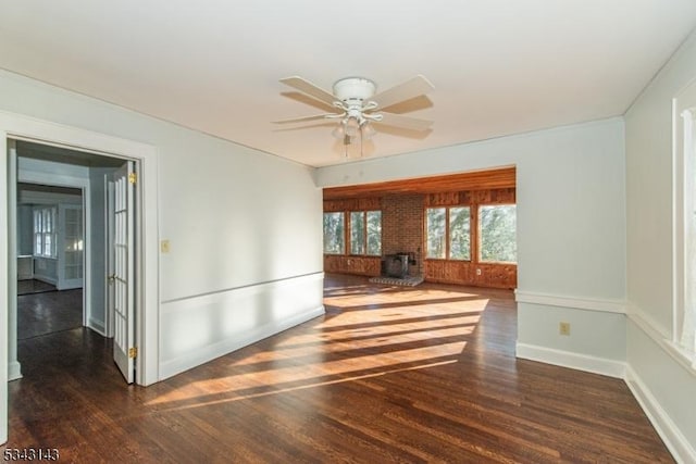 spare room featuring baseboards, wood finished floors, and a ceiling fan