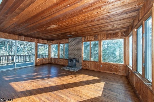 unfurnished sunroom with wooden ceiling and a wood stove