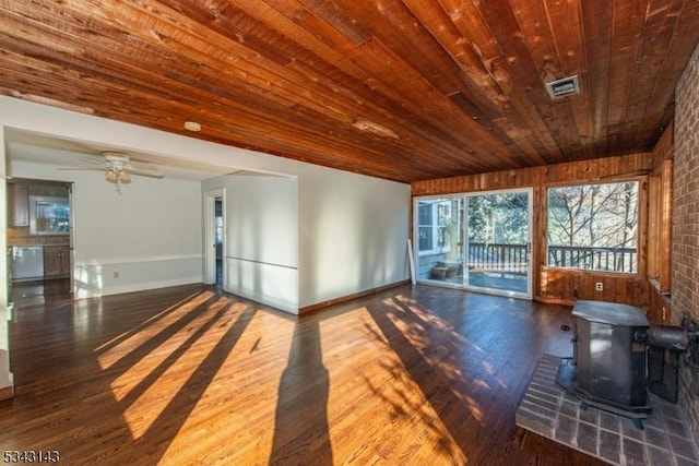 living area featuring wood finished floors, visible vents, a wood stove, ceiling fan, and wooden ceiling