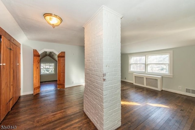 spare room featuring visible vents, radiator heating unit, baseboards, and hardwood / wood-style flooring