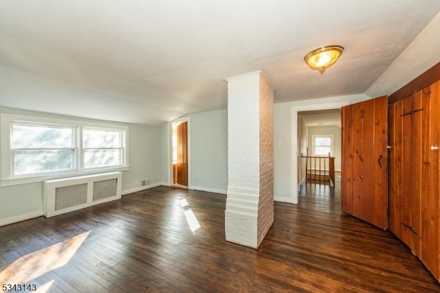 unfurnished room with dark wood-type flooring, radiator, a healthy amount of sunlight, and baseboards