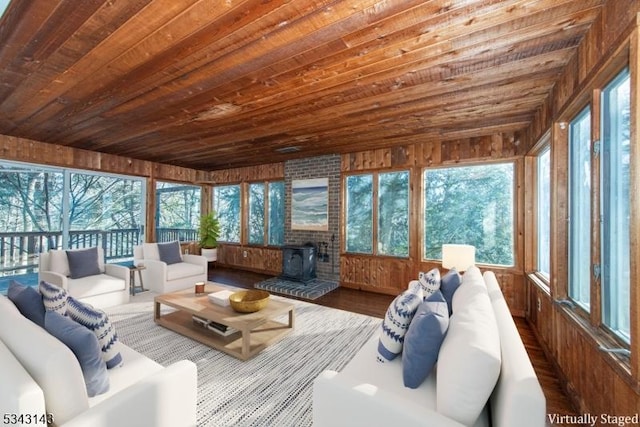 sunroom featuring wooden ceiling and a wood stove