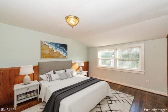 bedroom with lofted ceiling, baseboards, and wood-type flooring