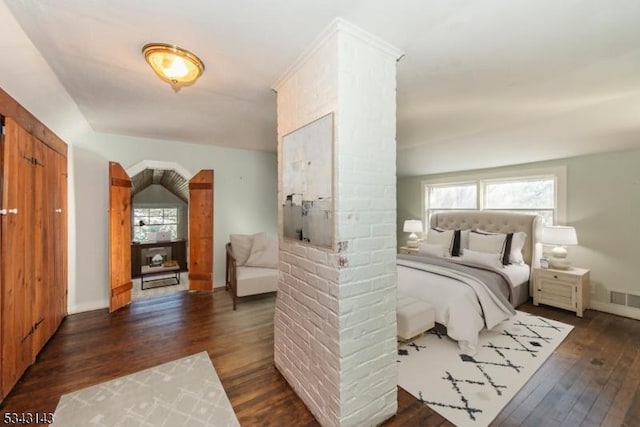 bedroom with visible vents, baseboards, and wood finished floors