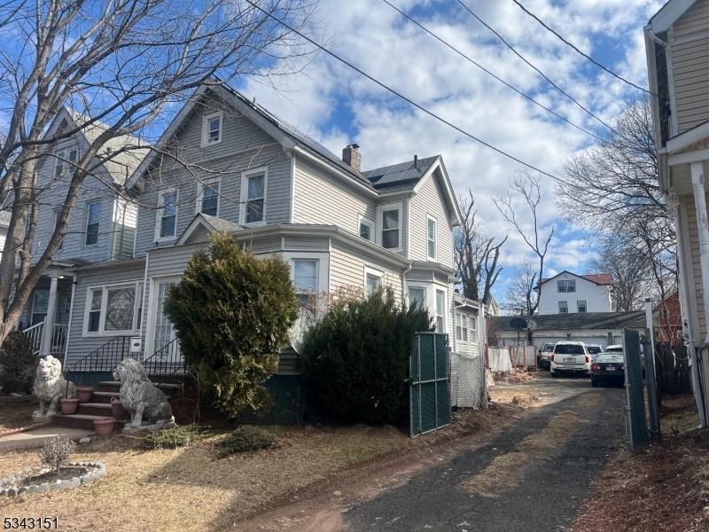 view of side of home featuring driveway and a chimney