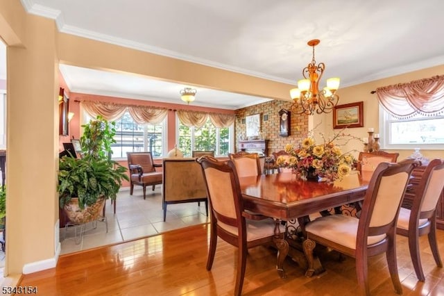 dining room featuring a notable chandelier, light wood-type flooring, and ornamental molding