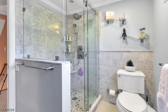 full bath featuring tile walls, toilet, crown molding, and a stall shower