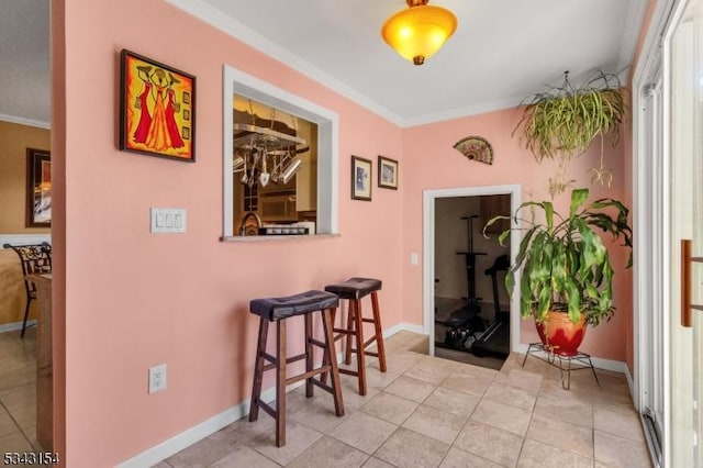 corridor featuring crown molding, baseboards, and tile patterned floors