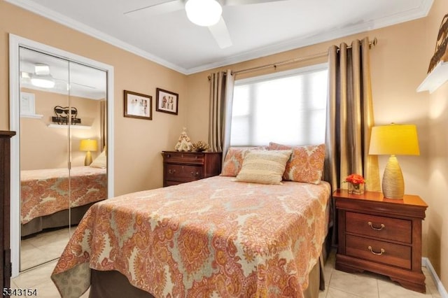 bedroom featuring crown molding, light tile patterned floors, a ceiling fan, and a closet