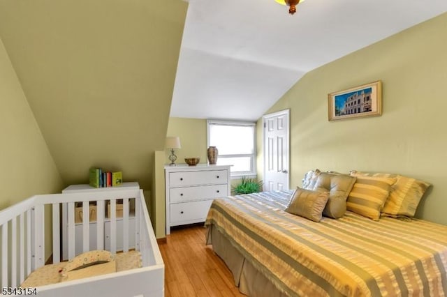 bedroom featuring lofted ceiling and light wood-type flooring