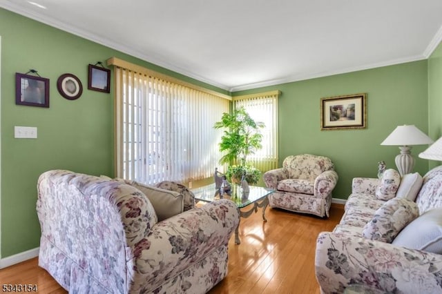 living area featuring crown molding, wood finished floors, and baseboards