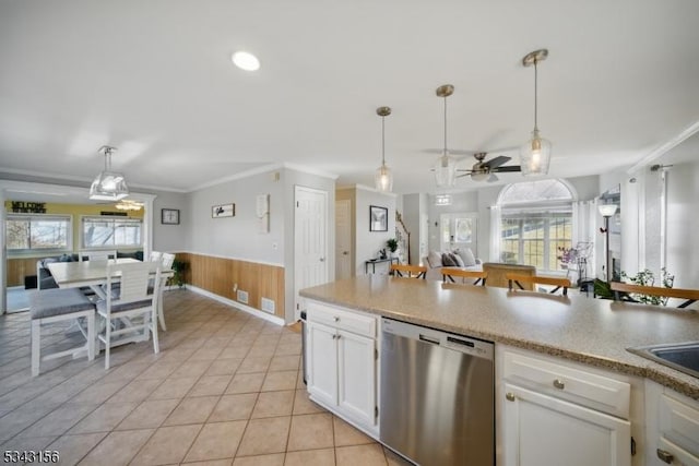 kitchen featuring white cabinetry, hanging light fixtures, wainscoting, dishwasher, and crown molding