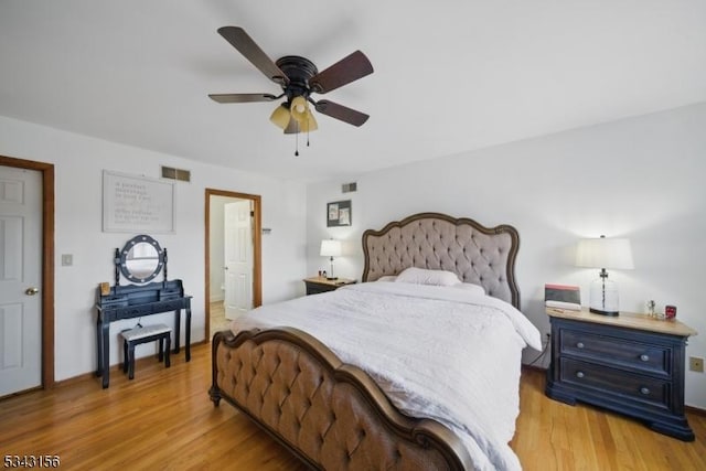 bedroom with visible vents, light wood-style flooring, and a ceiling fan