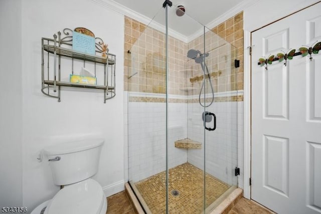 full bath featuring baseboards, toilet, ornamental molding, and a shower stall