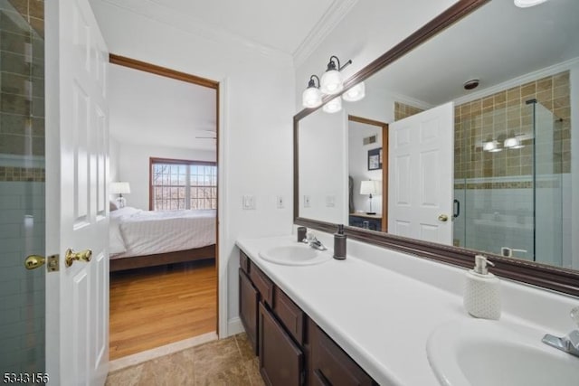 ensuite bathroom featuring a sink, connected bathroom, a shower stall, and crown molding