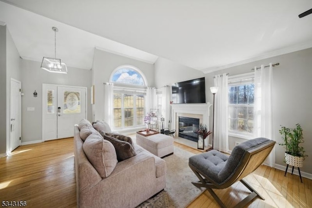 living area featuring lofted ceiling, a healthy amount of sunlight, and light wood-type flooring