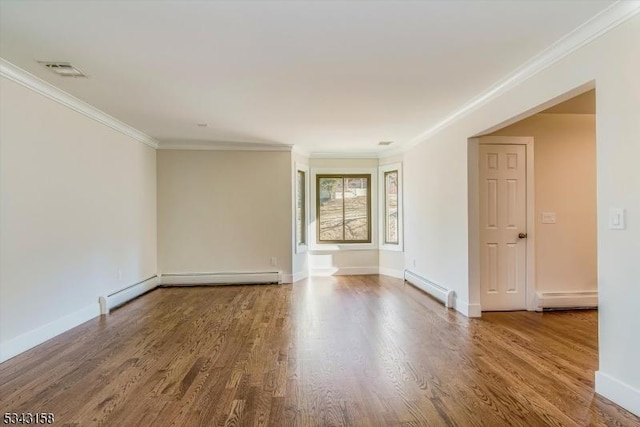 empty room with baseboard heating, visible vents, and wood finished floors