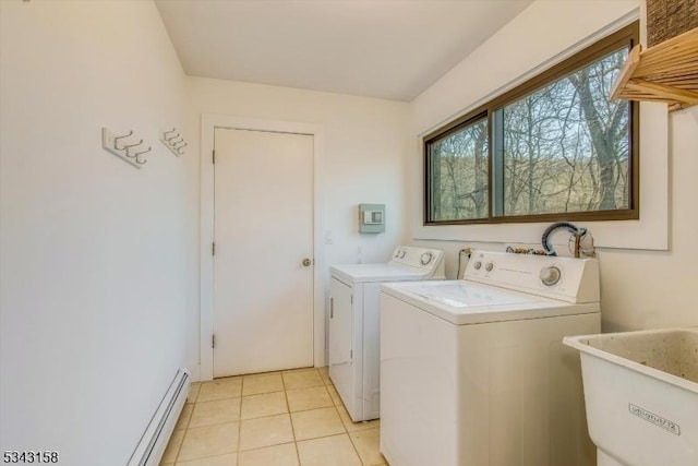 laundry area with light tile patterned floors, laundry area, baseboard heating, washer and dryer, and a sink