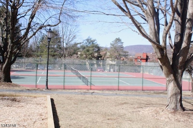 view of sport court featuring community basketball court, fence, and a mountain view