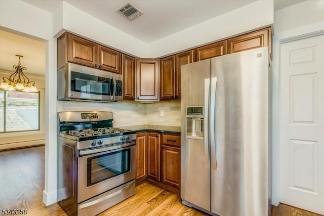 kitchen featuring visible vents, light wood-style floors, appliances with stainless steel finishes, and brown cabinetry