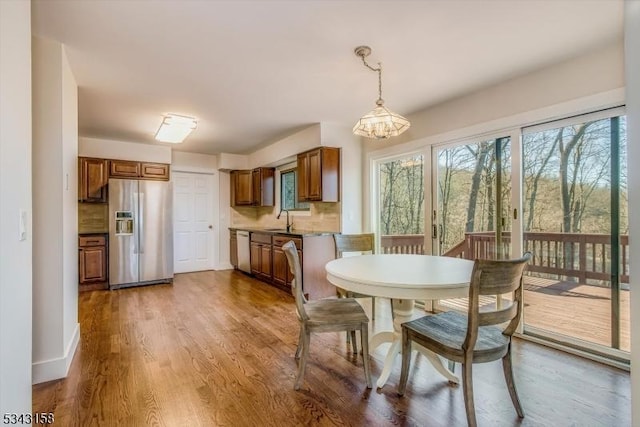 dining room with a notable chandelier, wood finished floors, and baseboards