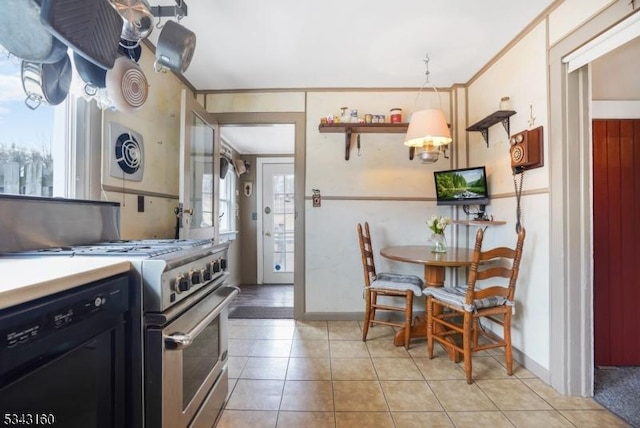 kitchen featuring light tile patterned floors, ornamental molding, high end stove, black dishwasher, and dark cabinets