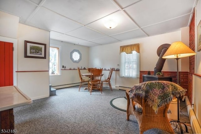 living area with a baseboard radiator, a paneled ceiling, and carpet floors