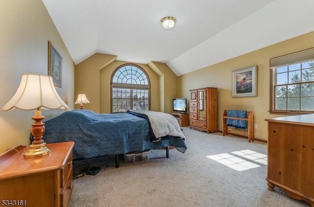 carpeted bedroom featuring baseboards and vaulted ceiling