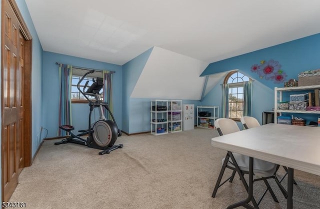 carpeted home office featuring a healthy amount of sunlight, baseboards, and vaulted ceiling