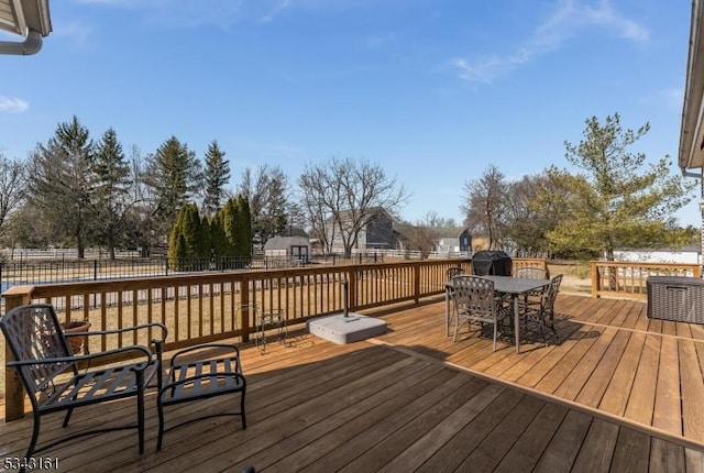 wooden terrace featuring outdoor dining space and fence